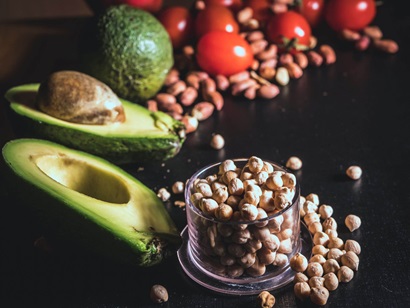 The image shows avocado and nuts, which are examples of healthy unsaturated fat sources to include in your diet