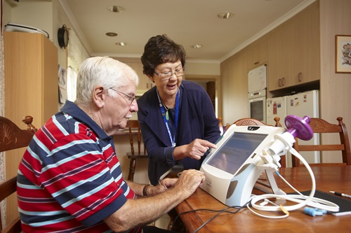 Telehealth nurse shows a patient how to use the home monitoring system.