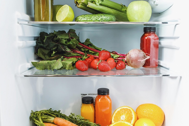 Fruit and veggies on a fridge shelf