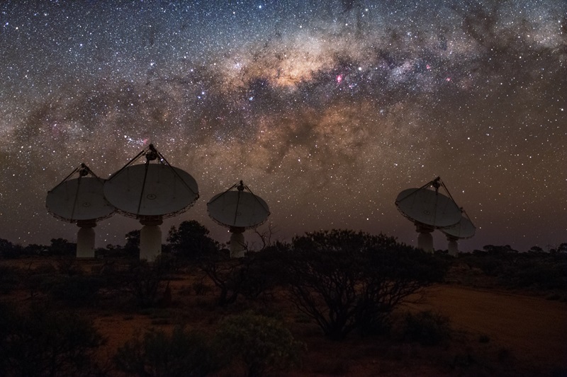 Five dishes of the ASKAP radio telescope seen at night with a band of stars above