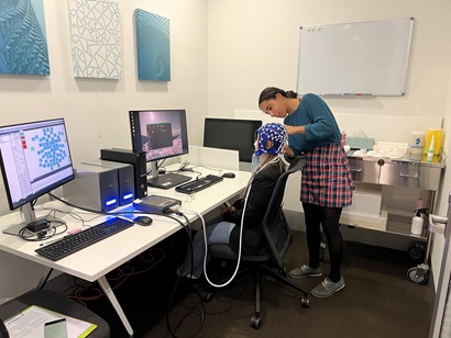 Student using a neuroimaging machine with a patient