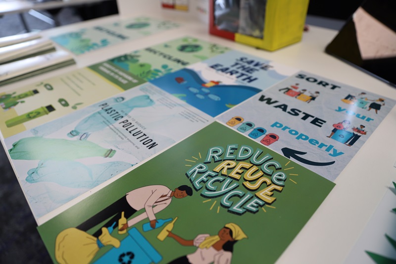 An assortment of posters about recycling laying on a table