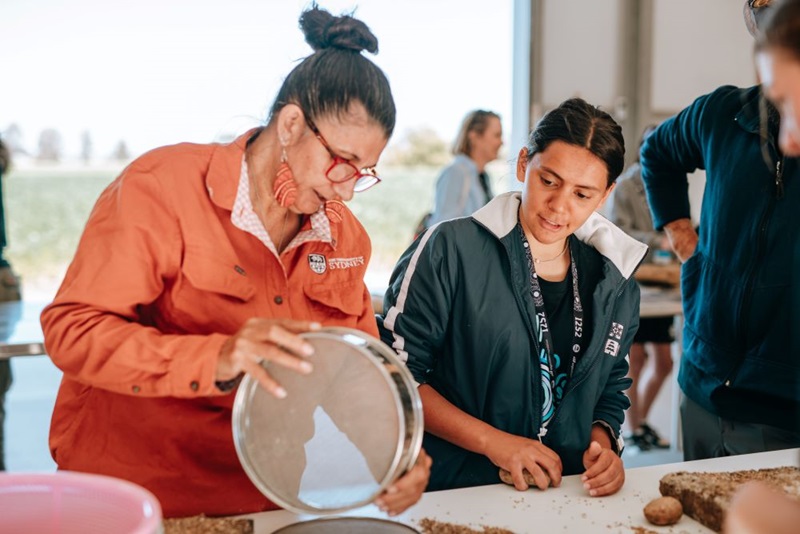 Camp Knowledge Holder, Aunty Di teaching students about native grains