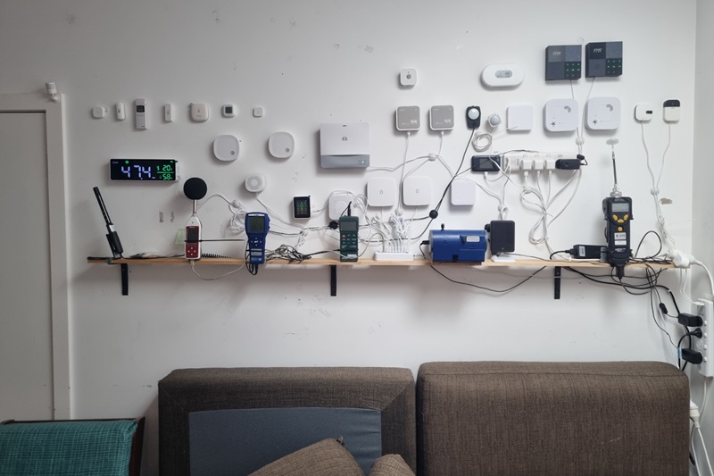 Collection of IT devices attached to a wall above a couch.