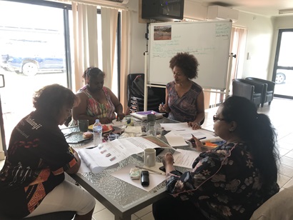 Women sitting around a table together with documents and whiteboard in background. Pictured Marceil Lawrence, Sharon Brady, and Natasha Brady from Western Yalanji Aboriginal Corporation planning the Western Yalanji prospectus with Pethie Lyons from CSIRO.
