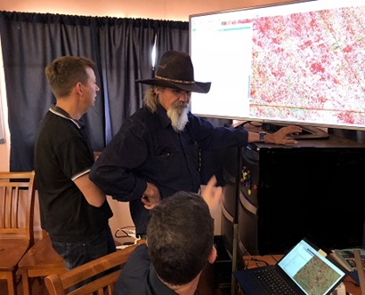 Three men looking at computers and large screens. Senior Custodian of Peedamulla Trevor Parker discusses groundwater resources on Peedamulla with Chief Executive Officer of Ashburton Aboriginal Corporation Steven Sonneman-Smith and CSIRO staff.