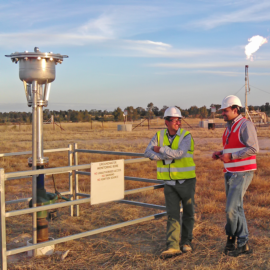 Researchers stand at a groundwater bore assessing its sustainability.