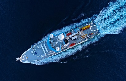 Aerial shot from directly overhead of a ship on the ocean.