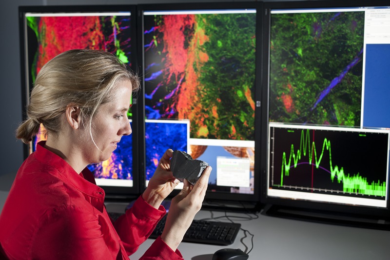 Woman infront of detailed graphic images on a screen