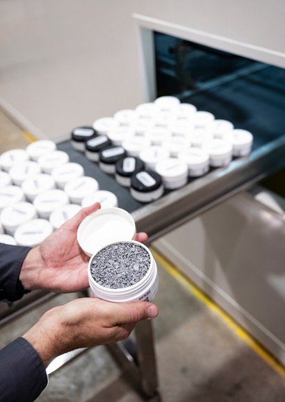 Hand holding sample above production line of samples