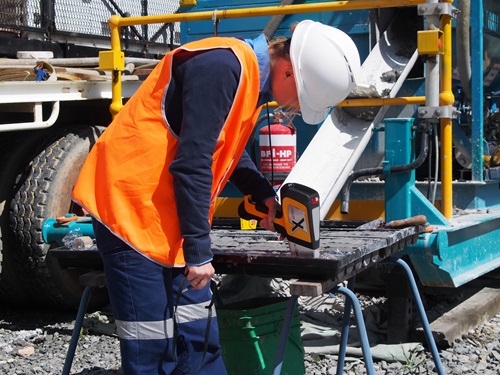 Female researcher, Dr Yulia Uvarova, overlooking rock core sample at a test site