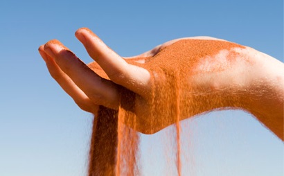 Mineral sand falling through someone's hand