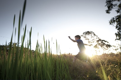 Child running through field 