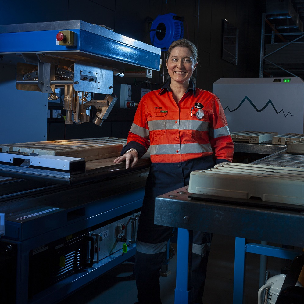 Female researcher stands beside scanning instrument