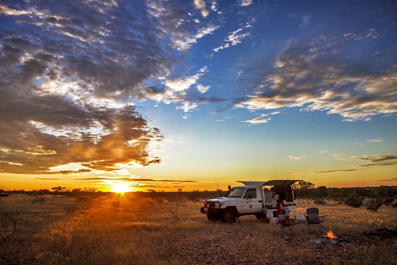 Four wheel drive car parked in outback landscape at sunset