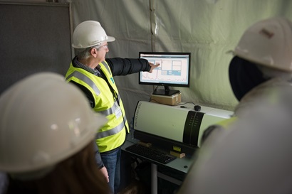 Man in hard hat pointing at monitoring screen