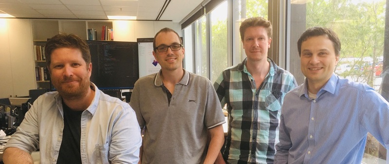 Four men standing in an office