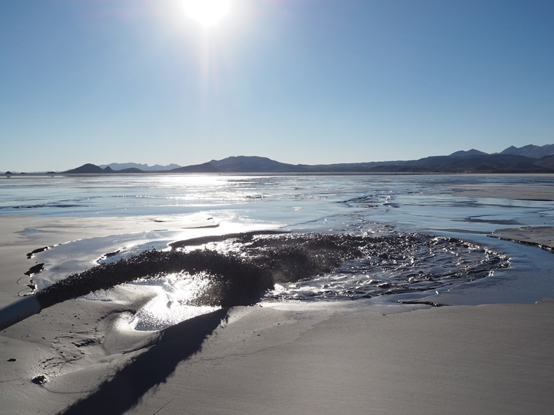 Close up of water swirling on a sandy beach