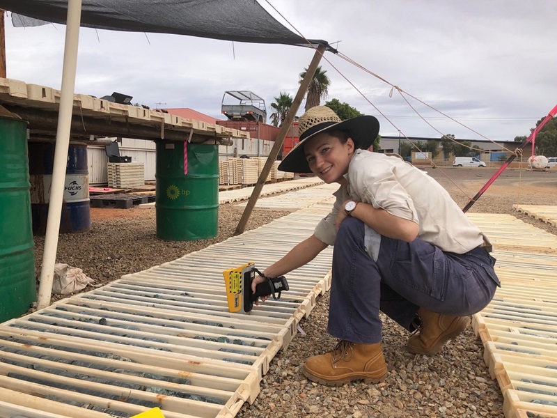 Woman holding portable XRF device over drill cores