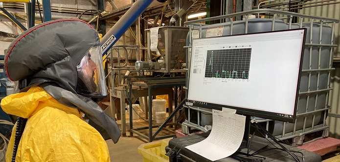 Person in full PPE looking at data on a computer screen