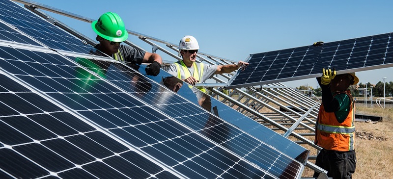 Three men installing solar panels