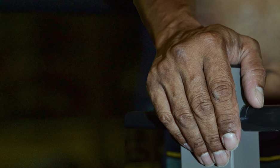 A close-up of an indigenous Australian man's hand in hospital