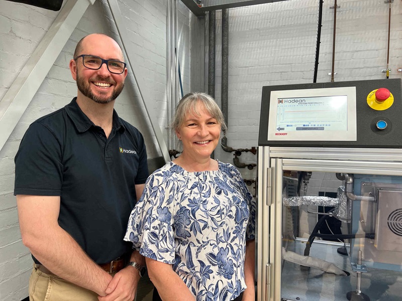 A man and a woman standing in front of an industrial cabinet