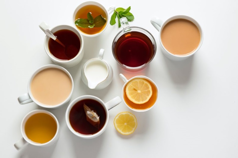 Mugs of tea arranged seen from a birds eye view, with different teas arranged.
