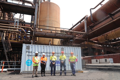 Sarb Giddey (CSIRO), Gurpreet Kaur (CSIRO), Shannon Ballard (BlueScope), Chris Rowland (Hadean Energy) and Michael Biro (BlueScope) outside the shipping container housing the electrolyser at BlueScope in Port Kembla, NSW.