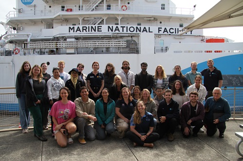 A group of people on a wharf next to a ship.