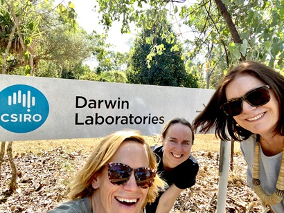 Three researchers pose before a board that says Darwin Laboratories