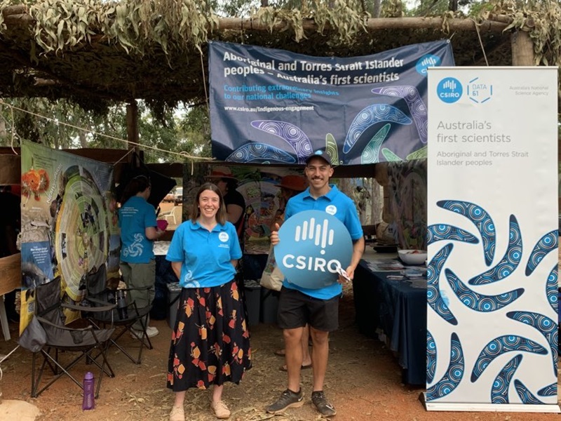 Isaak and a colleague standing in front of the CSIRO booth at Garma