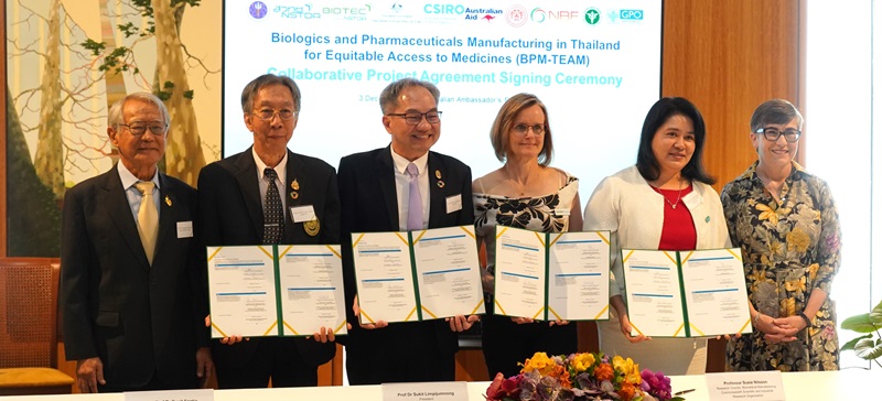 Australian and Thai representatives posing with signed documents in Thailand.