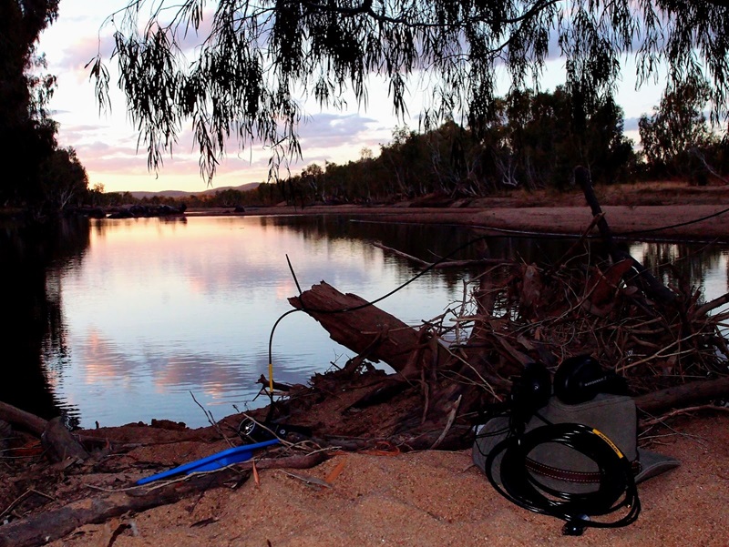 A set of headphones and recording equipment set up in front of a billabong at a property in Far North Queensland at Sunset. Image by Simon Linke.