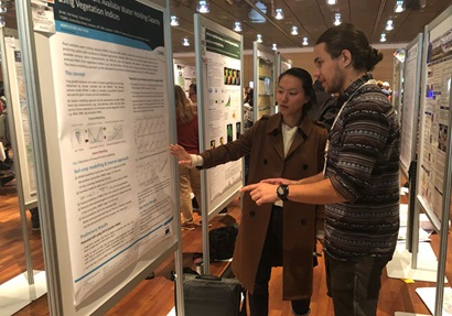 Agriculture and Food researcher, Dr Di He is discussing a scientific poster with a colleague at ISEM conference 2019.