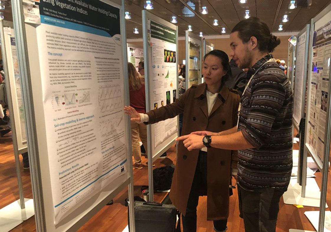 Agriculture and Food researcher, Dr Di He is discussing a scientific poster with a colleague at ISEM conference 2019.