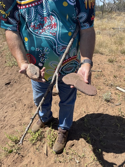 Person holding Yuwaalaraay objects. 