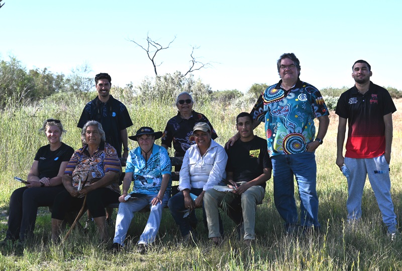 Group of people sitting and standing in grassland 