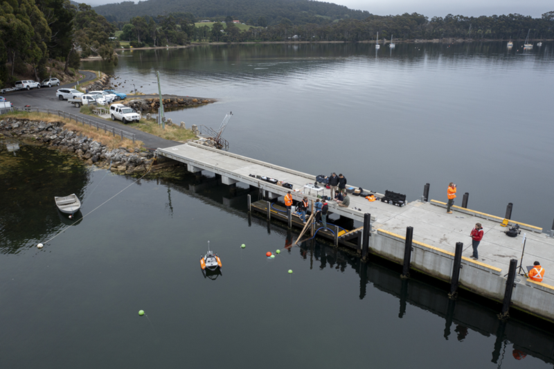 An aerial view of a wharf, where scientists are working in the field to monitor the ocean.