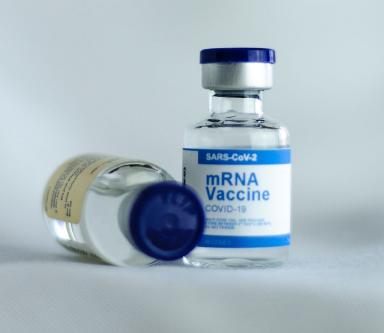 Image of a small blue and white bottle of vaccine with syringe